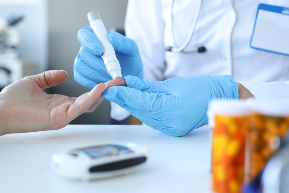 Doctor taking blood sample for blood sugar level test